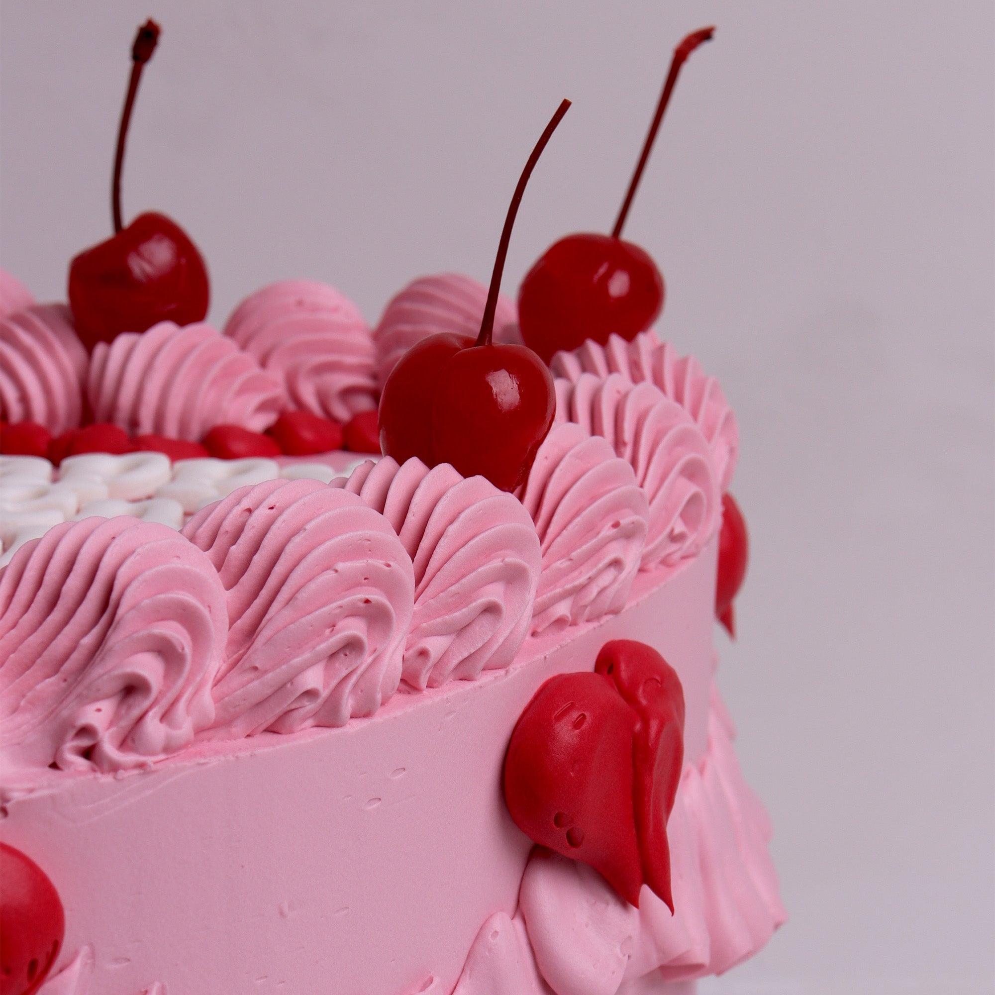 Pink retro heart cake with cherries and piped ruffles