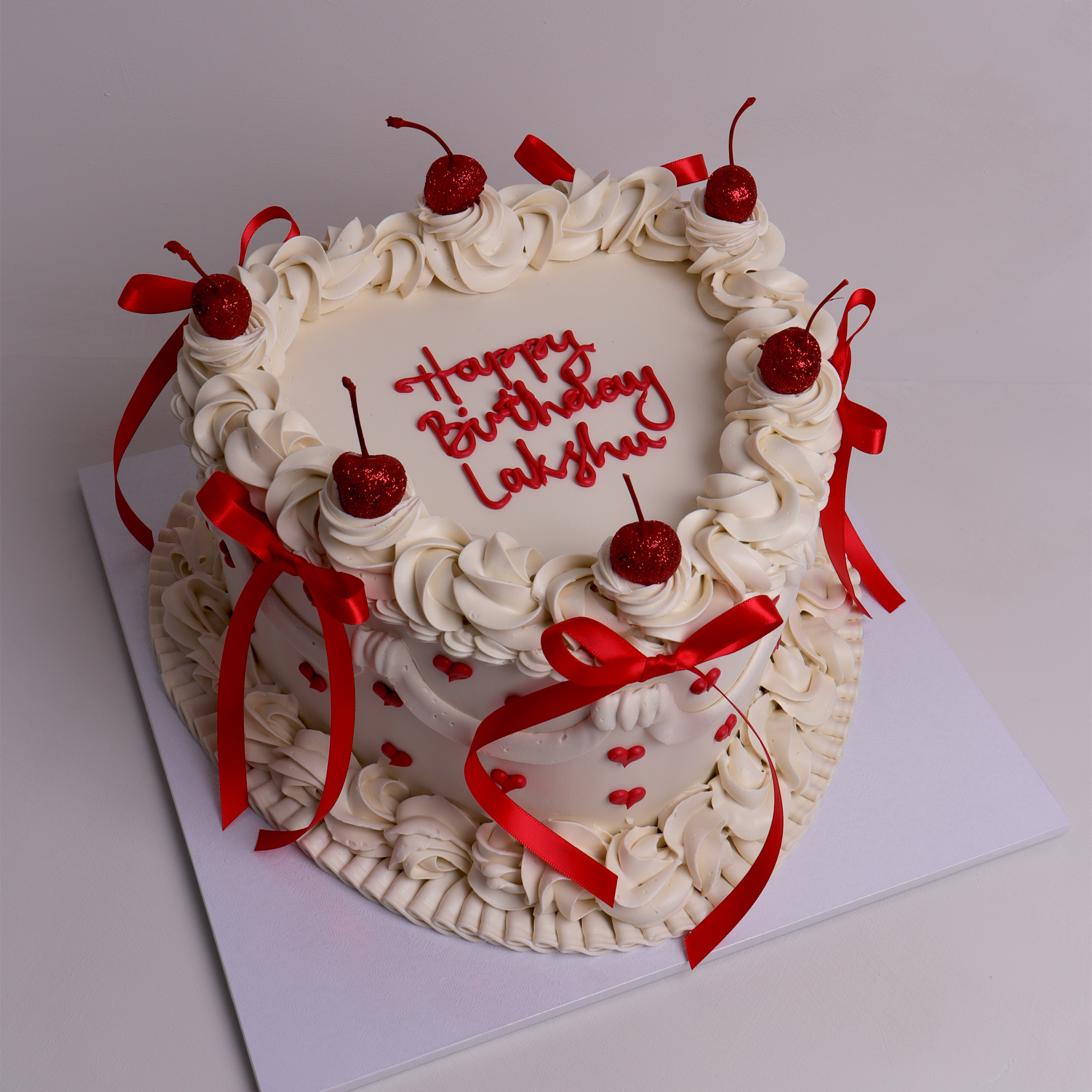 Heart-shaped retro heart cake with piped buttercream, red ribbon bows, cherries and mini heart details – perfect for birthdays and romantic celebrations in Melbourne